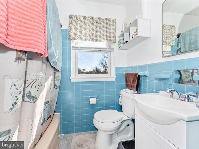 full bathroom with shower / tub combo, vanity, tile walls, and toilet