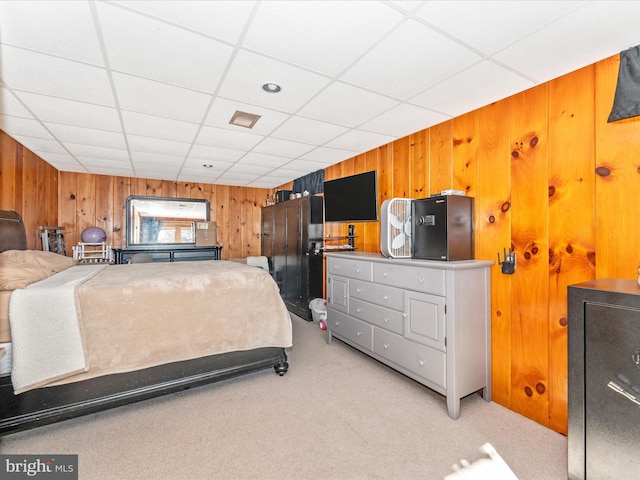 carpeted bedroom with a drop ceiling and wooden walls