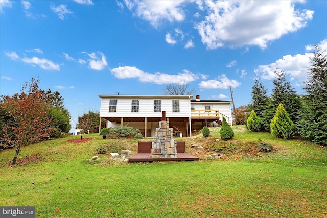 rear view of house featuring a yard and a deck