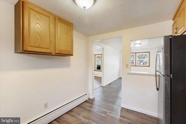 kitchen featuring stainless steel fridge, dark hardwood / wood-style flooring, a baseboard radiator, and light brown cabinets