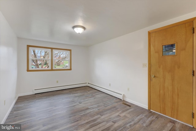 unfurnished room with light wood-type flooring and baseboard heating