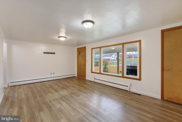 spare room with light hardwood / wood-style flooring and a baseboard heating unit