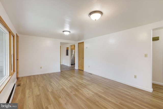 spare room with light hardwood / wood-style flooring and a baseboard heating unit