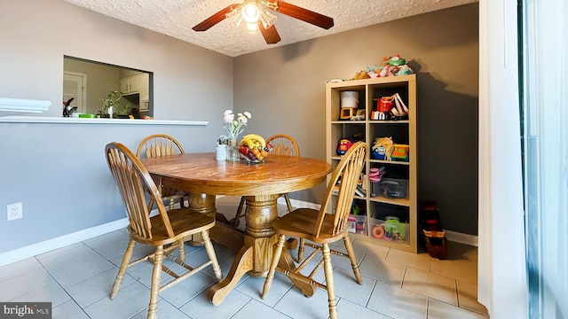 dining area with tile patterned flooring, ceiling fan, and a textured ceiling