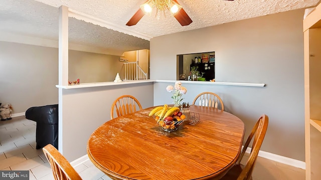 dining space with ceiling fan and a textured ceiling