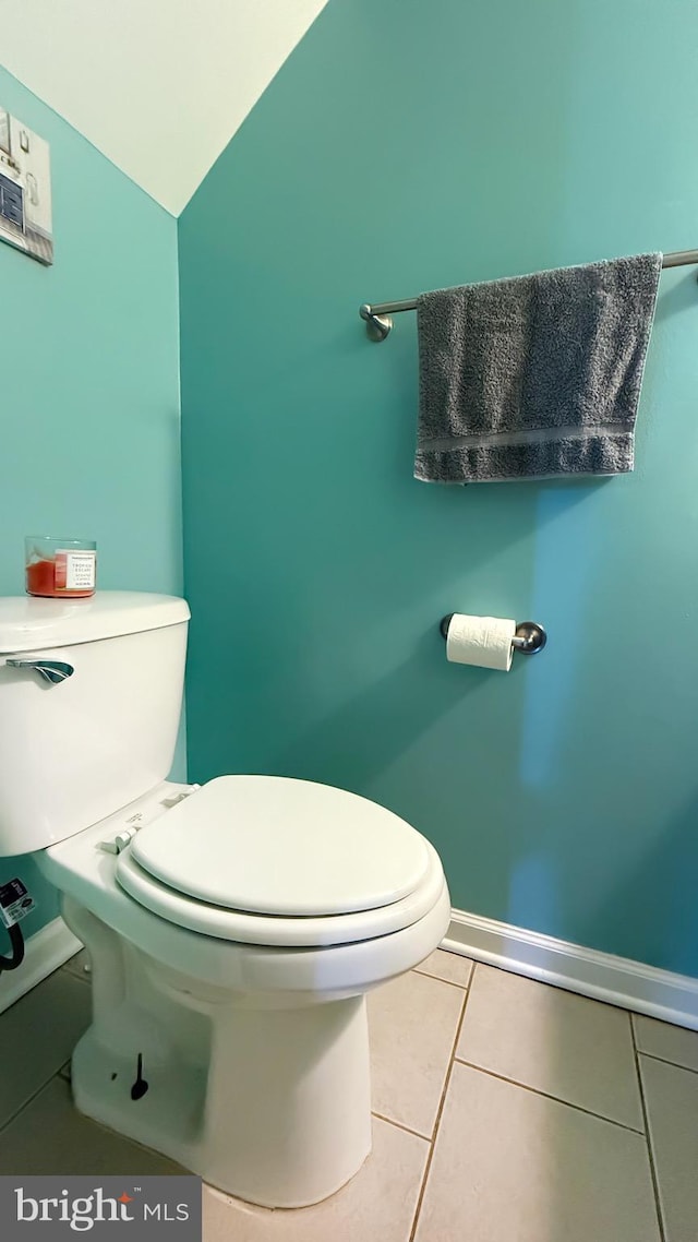 bathroom featuring tile patterned floors, lofted ceiling, and toilet