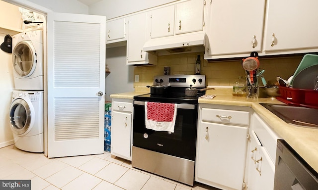 kitchen with stainless steel appliances, light tile patterned floors, stacked washer and dryer, decorative backsplash, and white cabinets