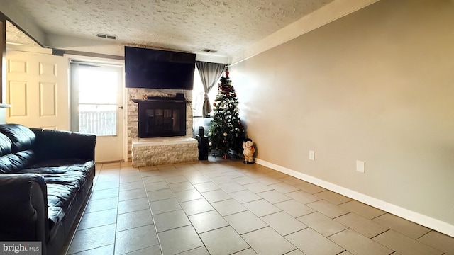 unfurnished living room featuring a stone fireplace, light tile patterned floors, and a textured ceiling