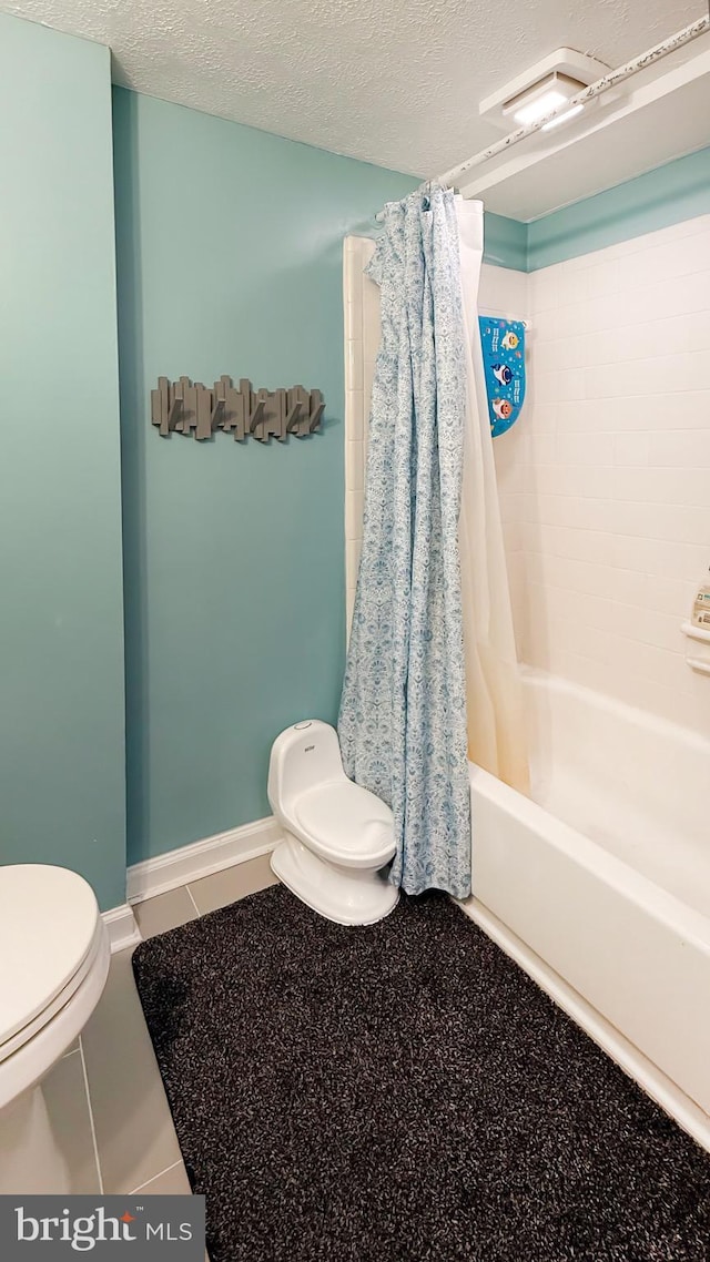 bathroom with shower / tub combo with curtain, tile patterned flooring, a textured ceiling, and toilet