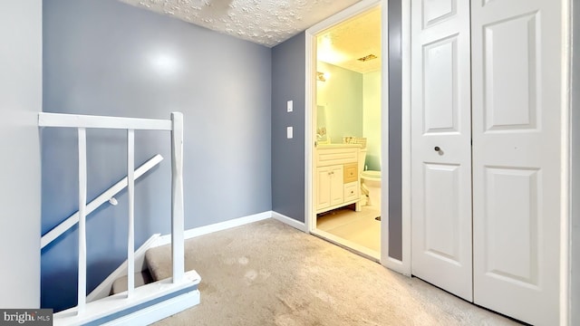 hallway featuring carpet and a textured ceiling