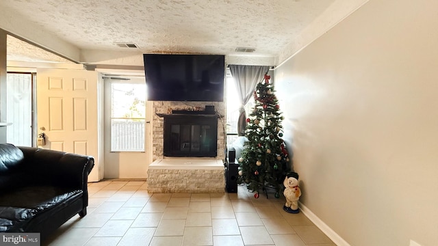 tiled living room featuring a fireplace and a textured ceiling