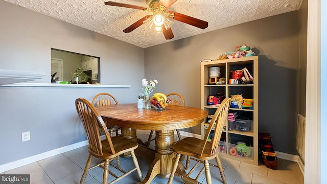 tiled dining area featuring a textured ceiling and ceiling fan