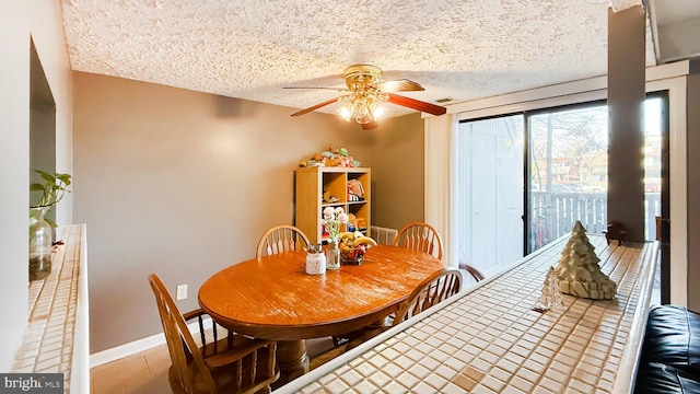 dining space featuring ceiling fan and a textured ceiling