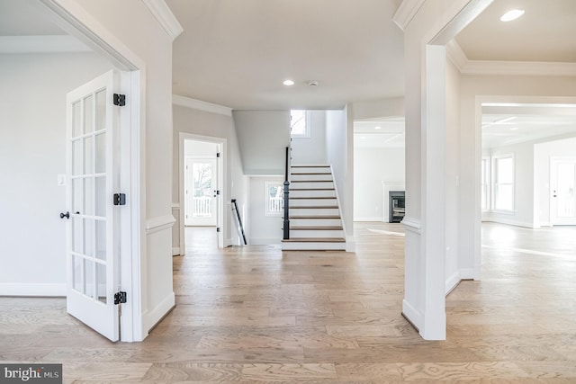 hall featuring ornamental molding and light hardwood / wood-style flooring