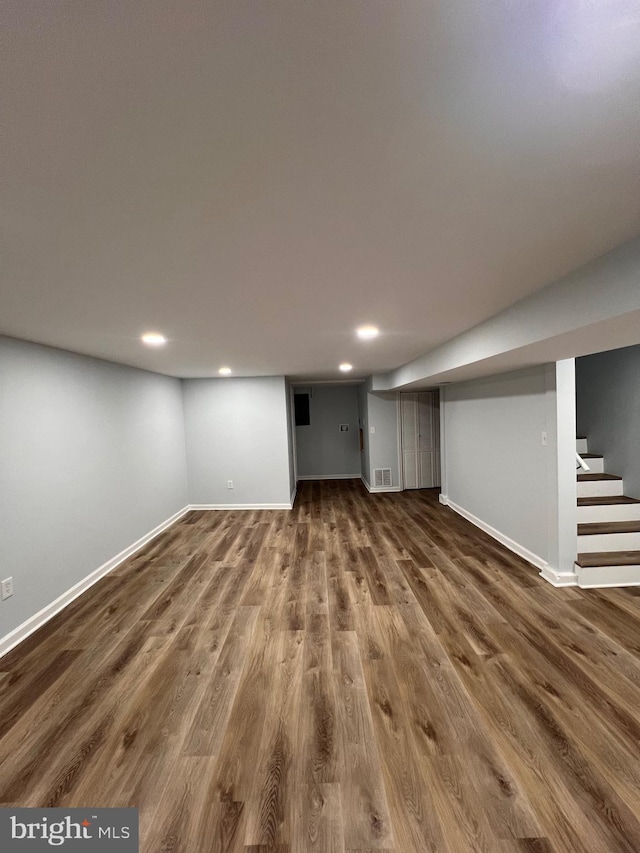 basement with dark hardwood / wood-style flooring