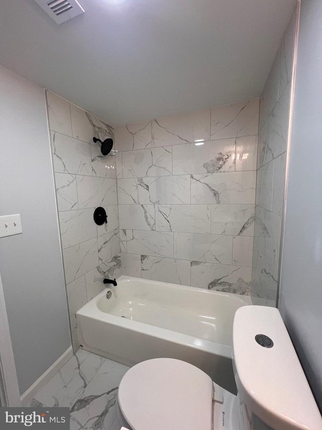 bathroom featuring toilet and tiled shower / bath