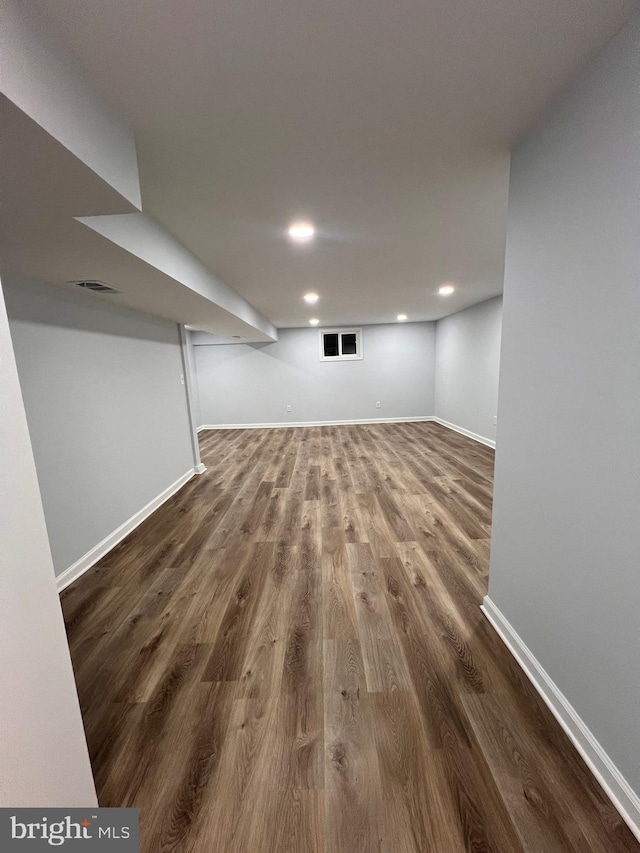 basement with dark hardwood / wood-style flooring