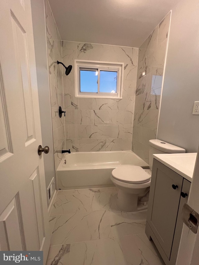 full bathroom with toilet, vanity, and tiled shower / bath