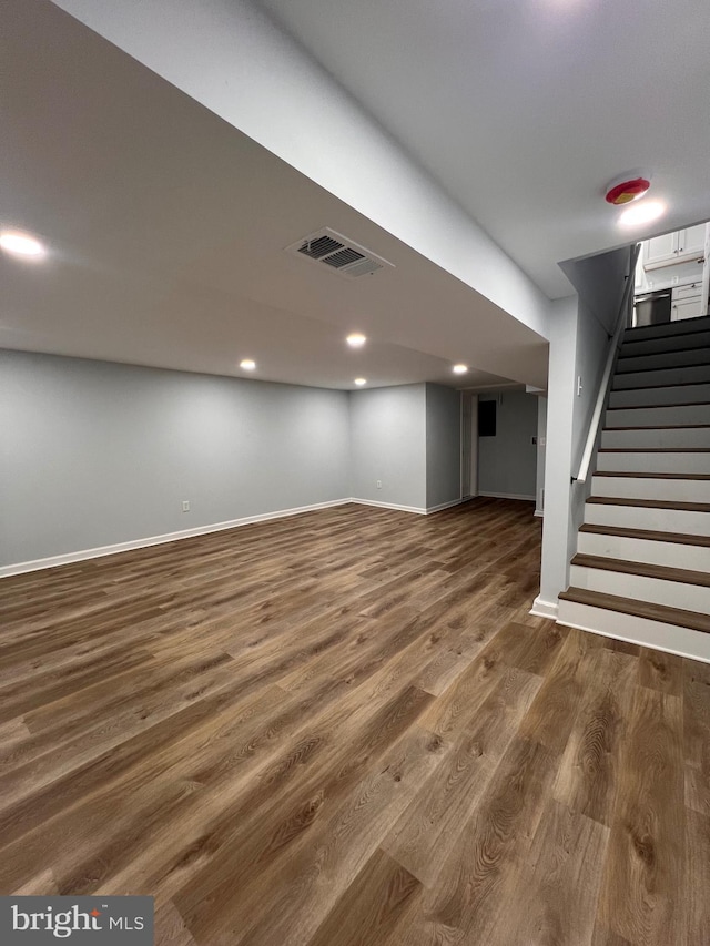 basement with dark hardwood / wood-style floors