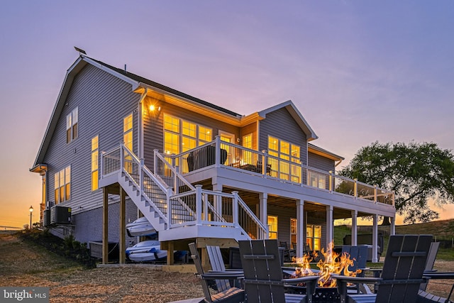 back house at dusk with an outdoor fire pit and a deck