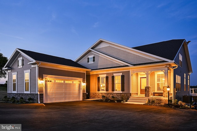 craftsman inspired home with a garage and a porch