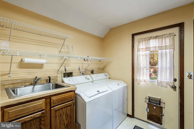 clothes washing area featuring cabinets, sink, and independent washer and dryer