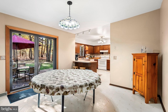 dining space featuring track lighting, ceiling fan, and sink