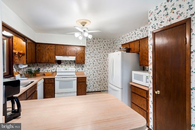 kitchen featuring kitchen peninsula, ceiling fan, and white appliances