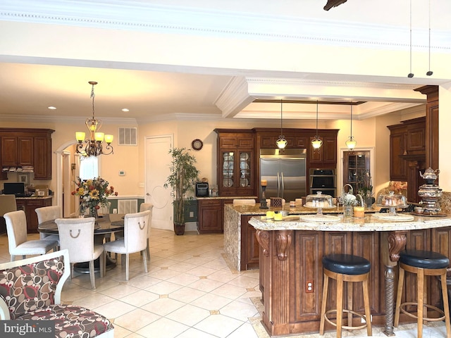 kitchen featuring stainless steel appliances, decorative light fixtures, and ornamental molding