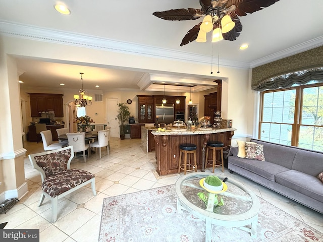 tiled living room featuring ornamental molding and ceiling fan with notable chandelier