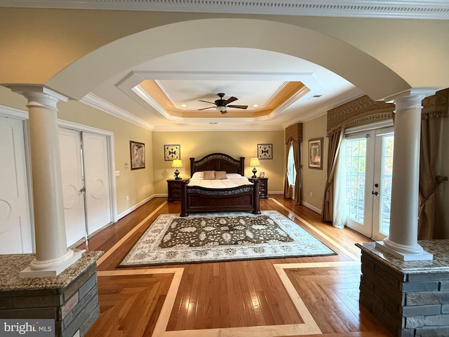 bedroom featuring access to exterior, ornamental molding, french doors, and a tray ceiling