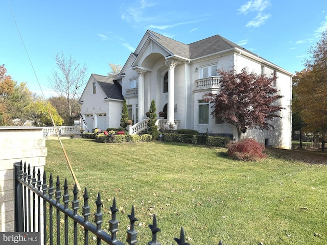 view of front of property with a garage, a front lawn, and a balcony