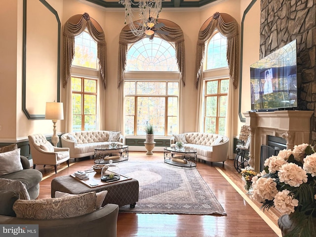 living room featuring a wealth of natural light, hardwood / wood-style flooring, and crown molding