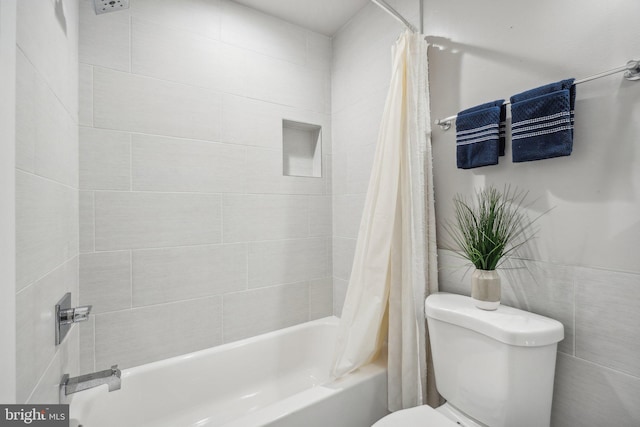 bathroom featuring toilet and shower / bath combination with curtain