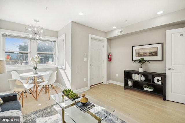 living room featuring light wood-type flooring and a chandelier