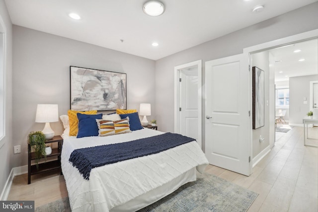 bedroom featuring light wood-type flooring and connected bathroom