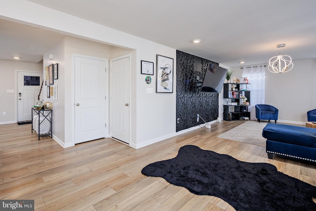 living room featuring light wood-type flooring and an inviting chandelier