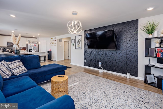 living room featuring light hardwood / wood-style flooring and a notable chandelier