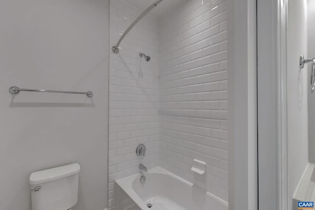 bathroom featuring toilet and tiled shower / bath