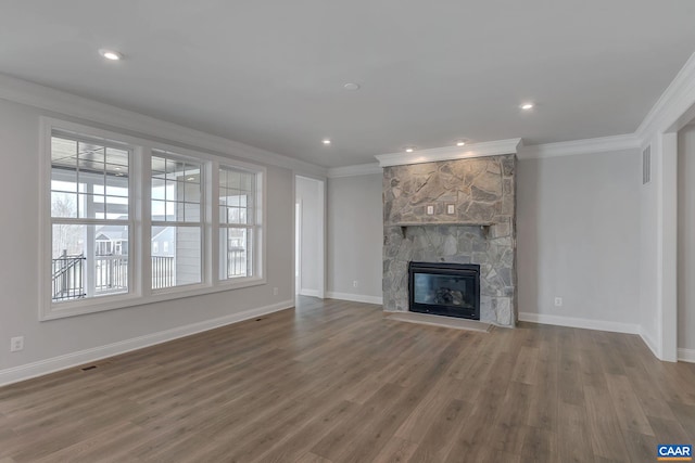 unfurnished living room featuring a stone fireplace, hardwood / wood-style flooring, and crown molding