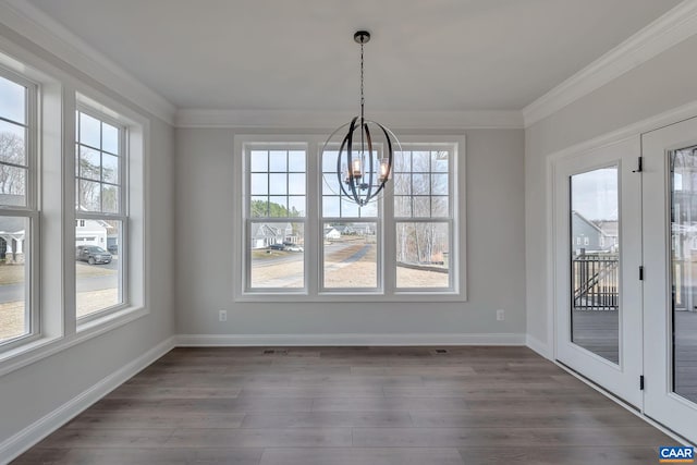 unfurnished dining area featuring dark wood-type flooring, plenty of natural light, and an inviting chandelier