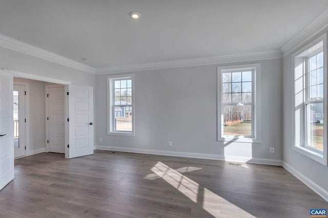 unfurnished room featuring ornamental molding, plenty of natural light, and dark wood-type flooring