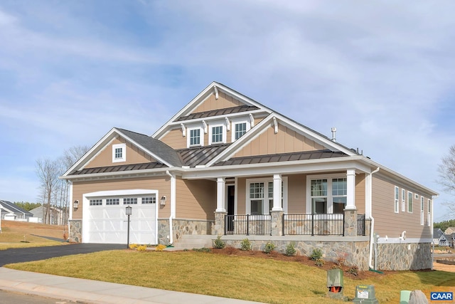 craftsman inspired home featuring a garage, covered porch, and a front yard