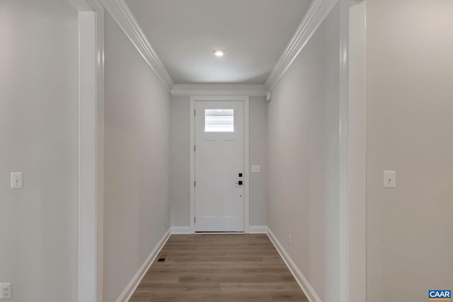 doorway with light hardwood / wood-style flooring and crown molding