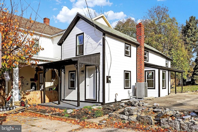 back of house featuring a porch and central AC