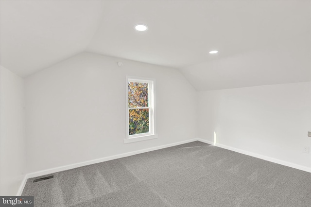 additional living space featuring lofted ceiling and carpet