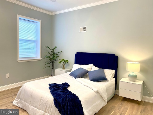 bedroom with crown molding and light wood-type flooring