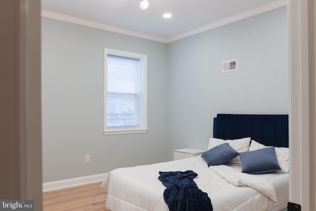 bedroom with light hardwood / wood-style flooring and crown molding