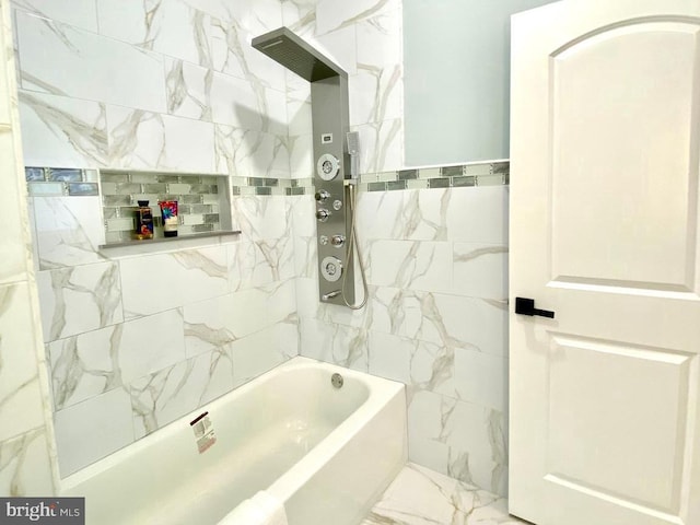 bathroom featuring tile walls and tiled shower / bath combo