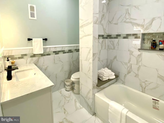 bathroom with vanity, toilet, tile walls, and a bathing tub